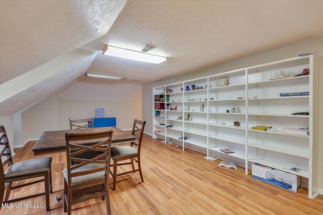 138 Oak Ridge Cir, Madison, MS 39110 - dining area featuring a textured ceiling, wood finished floors, vaulted ceiling, and baseboards