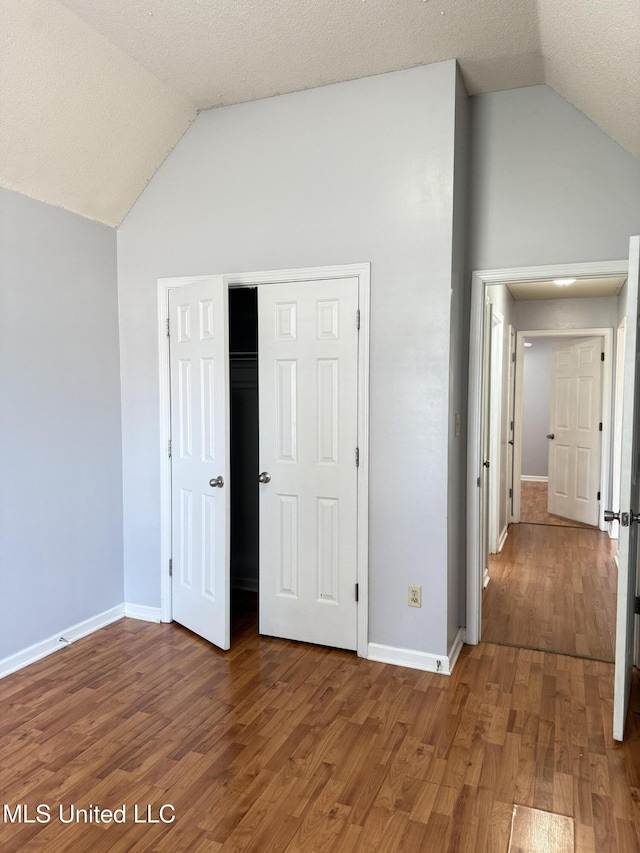 8373 Clubview Dr, Olive Branch, MS 38654 - unfurnished bedroom featuring wood finished floors, a closet, and high vaulted ceiling