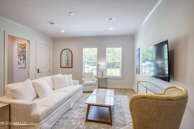 living area with light wood-type flooring, baseboards, visible vents, recessed lighting, and crown molding