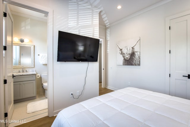 bedroom featuring a sink, recessed lighting, wood finished floors, connected bathroom, and ornamental molding