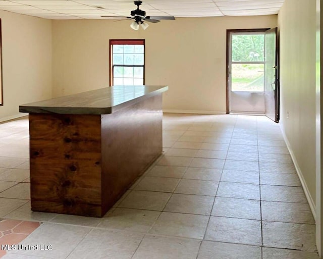 kitchen with light tile patterned flooring, plenty of natural light, and a drop ceiling