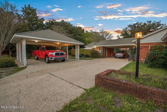 parking at dusk featuring a carport