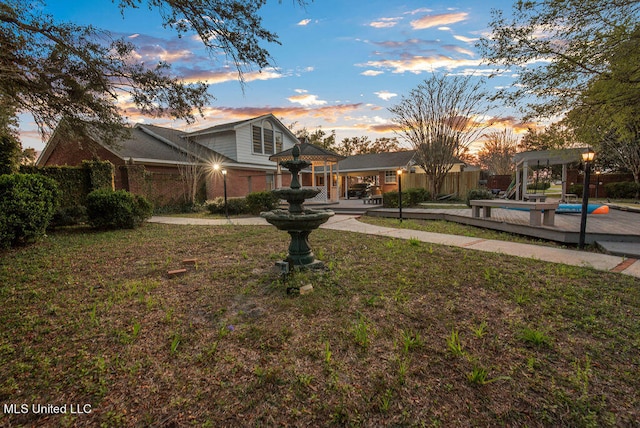 view of front of house featuring a patio area, a pool, and a lawn