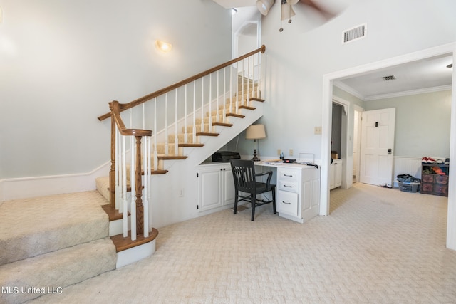 office area featuring built in desk, crown molding, light carpet, and a high ceiling