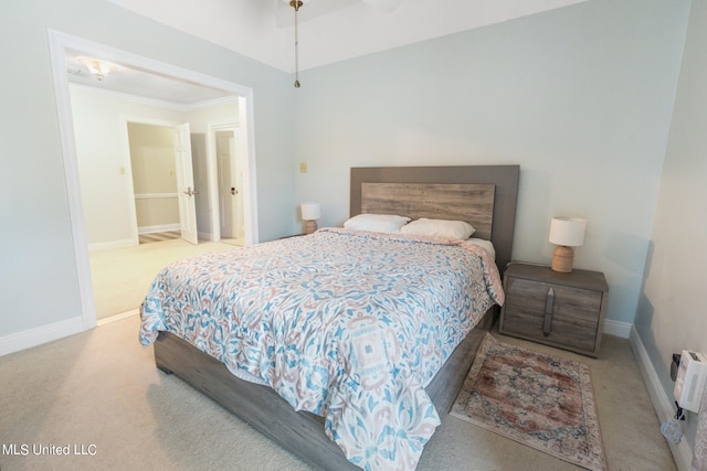 carpeted bedroom with ornamental molding and ensuite bathroom