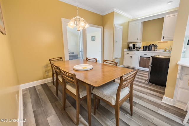 dining space with ornamental molding, a notable chandelier, and light wood-type flooring