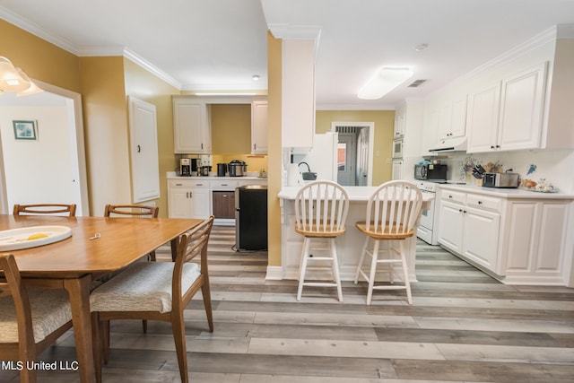 dining room with ornamental molding and light wood-type flooring