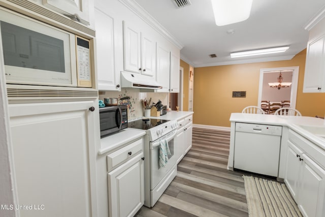 kitchen featuring ornamental molding, a notable chandelier, light wood-type flooring, white cabinetry, and white appliances