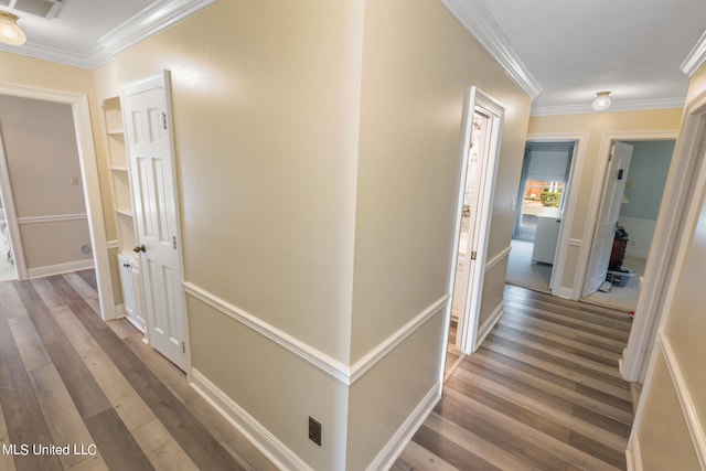 hall with ornamental molding and wood-type flooring