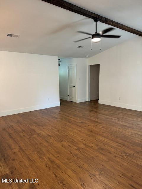 empty room with dark wood-type flooring, ceiling fan, and vaulted ceiling with beams