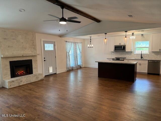 kitchen featuring decorative light fixtures, stainless steel appliances, a kitchen island, and white cabinets