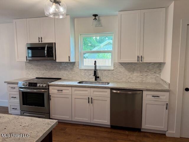 kitchen with stainless steel appliances, white cabinetry, dark hardwood / wood-style flooring, and sink