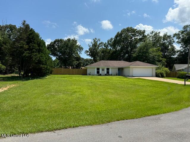 single story home featuring a front lawn and a garage