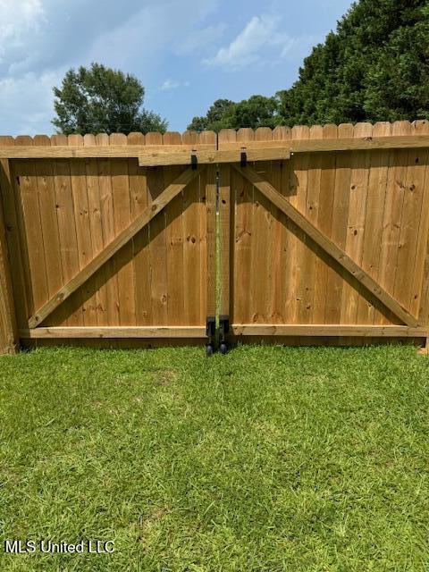 view of gate featuring a lawn