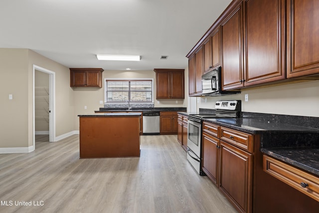 13239 Tyler Ln, Gulfport, MS 39503 - kitchen with appliances with stainless steel finishes, light wood-type flooring, baseboards, a sink, and a kitchen island