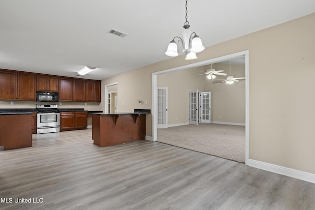 13239 Tyler Ln, Gulfport, MS 39503 - kitchen featuring stainless steel electric range, black microwave, french doors, dark countertops, and a kitchen breakfast bar