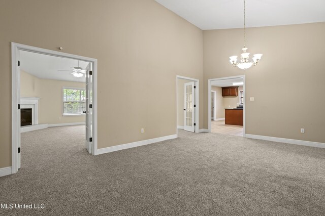 13239 Tyler Ln, Gulfport, MS 39503 - spare room with light carpet, a chandelier, a high ceiling, baseboards, and a ceiling fan