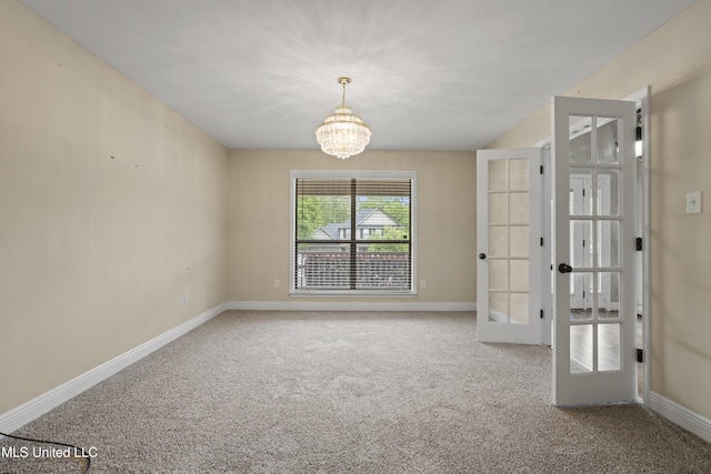 13239 Tyler Ln, Gulfport, MS 39503 - carpeted empty room featuring french doors, a chandelier, and baseboards