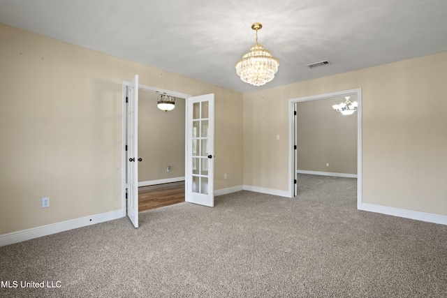 13239 Tyler Ln, Gulfport, MS 39503 - carpeted empty room featuring a chandelier, french doors, and baseboards