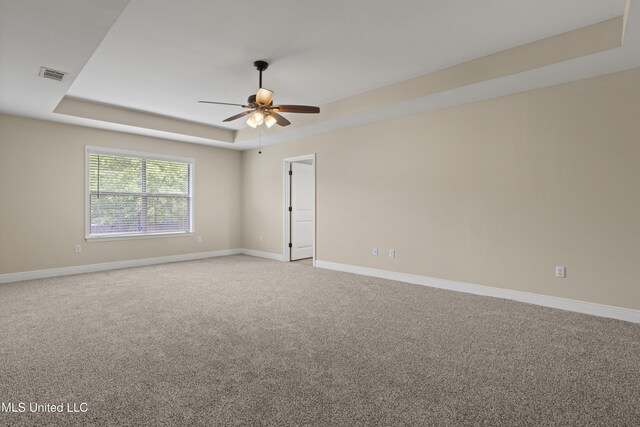 13239 Tyler Ln, Gulfport, MS 39503 - carpeted empty room with a tray ceiling, a ceiling fan, and baseboards