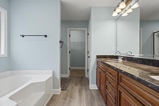 13239 Tyler Ln, Gulfport, MS 39503 - full bathroom featuring wood finished floors, a garden tub, double vanity, and a spacious closet