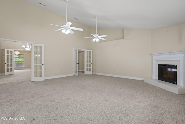 13239 Tyler Ln, Gulfport, MS 39503 - unfurnished living room with french doors, carpet floors, a glass covered fireplace, baseboards, and high vaulted ceiling