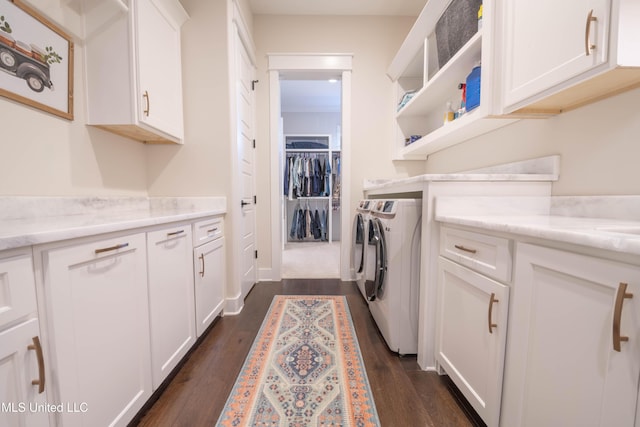 laundry area featuring independent washer and dryer, cabinets, and dark hardwood / wood-style flooring