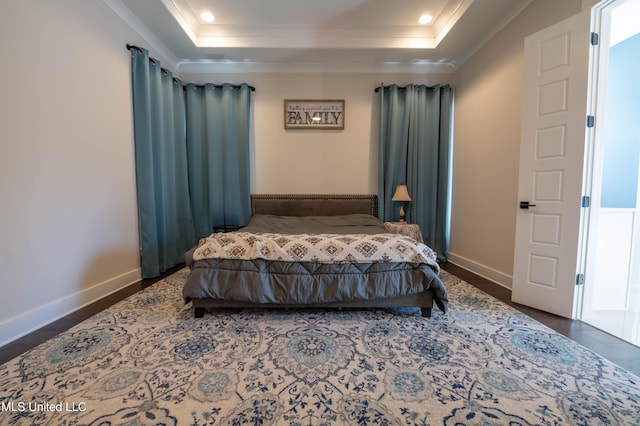 bedroom featuring crown molding, dark hardwood / wood-style floors, and a raised ceiling