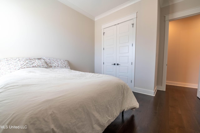 bedroom with a closet, crown molding, and dark wood-type flooring