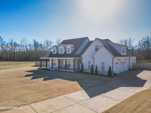 view of front of home with a garage, a front lawn, and a porch