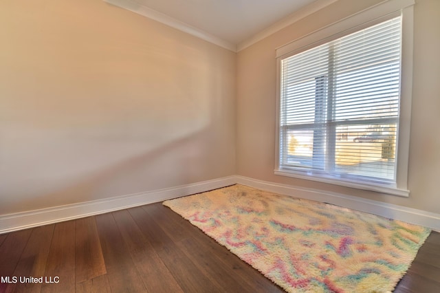 spare room featuring crown molding and dark wood-type flooring