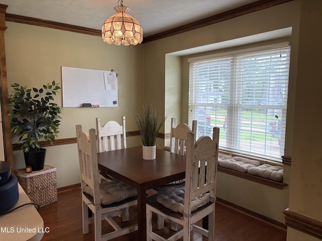 dining room with plenty of natural light, ornamental molding, and wood finished floors