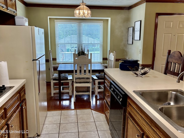 kitchen featuring pendant lighting, ornamental molding, a sink, and black appliances