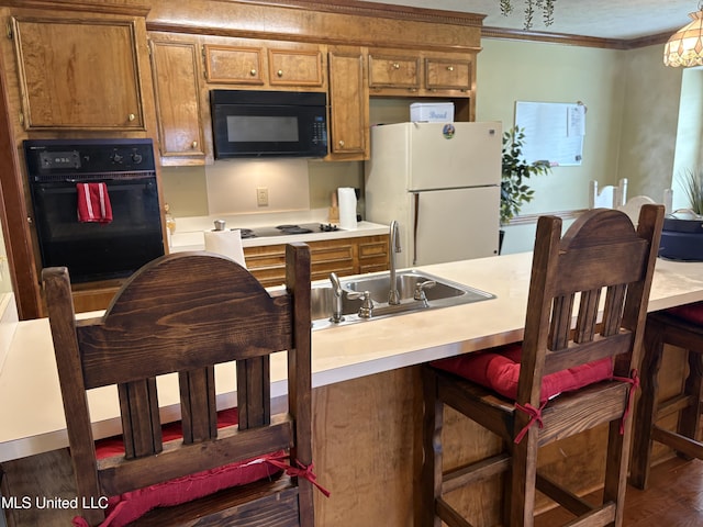 kitchen with brown cabinetry, a sink, light countertops, black appliances, and ornamental molding