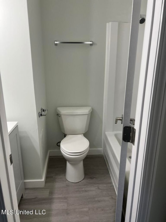 bathroom featuring toilet, hardwood / wood-style flooring, and vanity