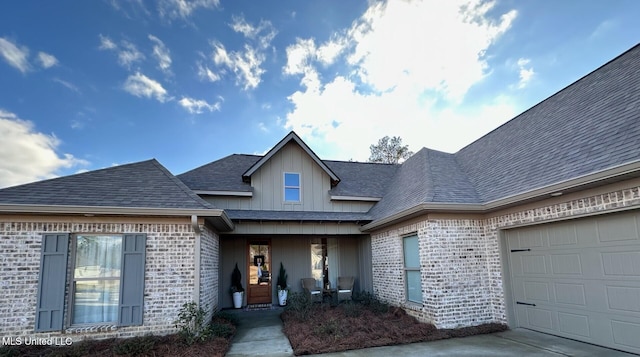 view of front facade with brick siding, roof with shingles, and an attached garage