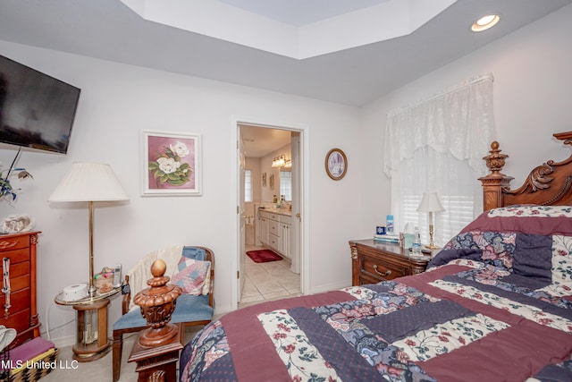 bedroom with light tile patterned floors and ensuite bathroom