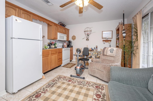 living room featuring light tile patterned flooring, ceiling fan, and a textured ceiling