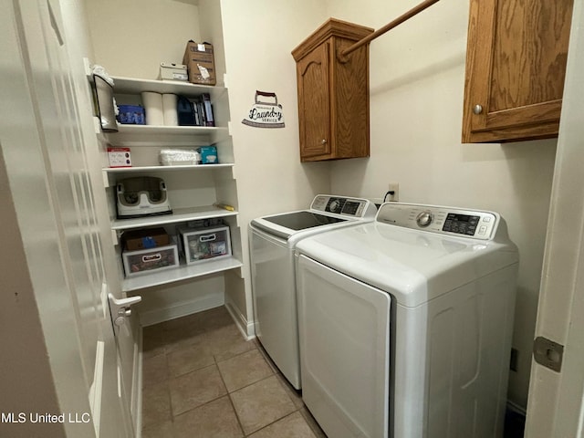 laundry room featuring light tile patterned floors, cabinets, and washing machine and clothes dryer