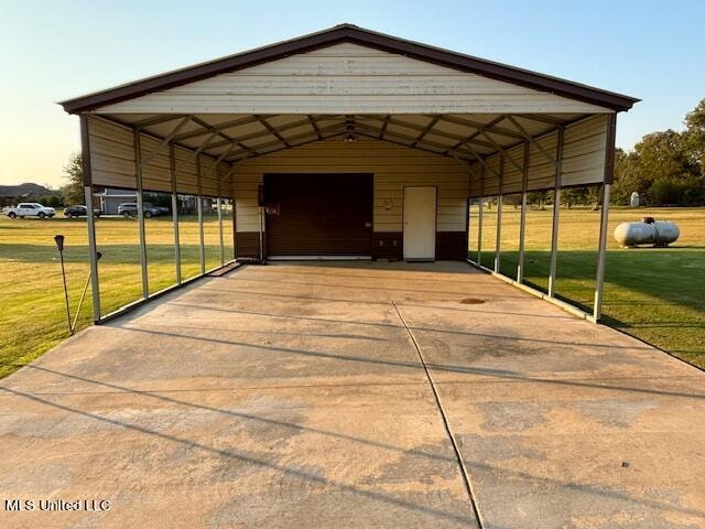 view of vehicle parking featuring a carport, a lawn, and a garage