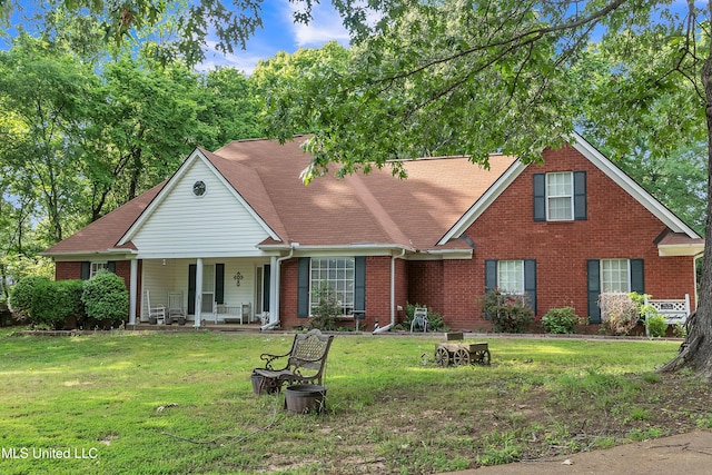 view of front of property featuring covered porch, brick siding, and a front yard