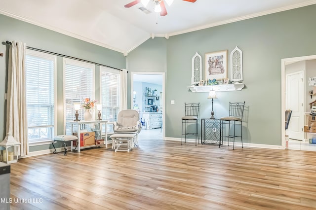 sitting room with a ceiling fan, ornamental molding, wood finished floors, baseboards, and vaulted ceiling