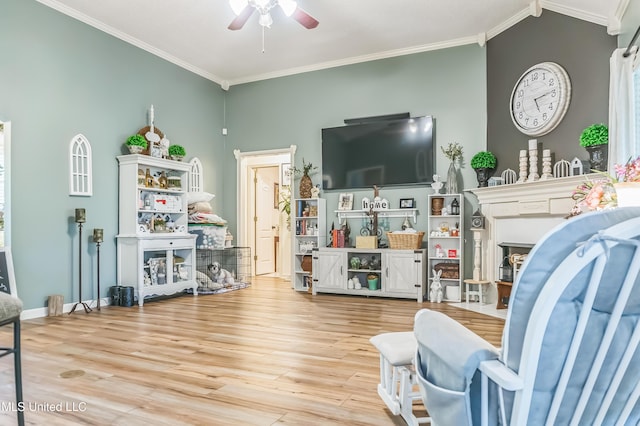 living room with ceiling fan, crown molding, wood finished floors, a fireplace, and lofted ceiling