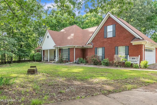 traditional-style house featuring brick siding, an attached garage, a front yard, and covered porch