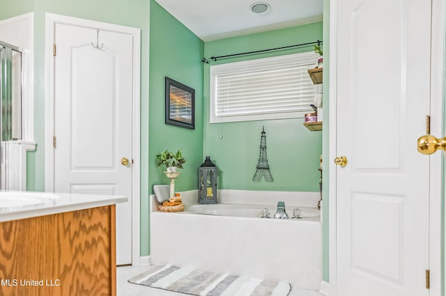 bathroom featuring a garden tub and vanity