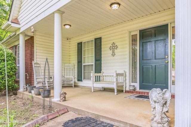 property entrance with covered porch and brick siding