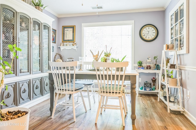 dining area featuring ornamental molding, wood finished floors, and baseboards
