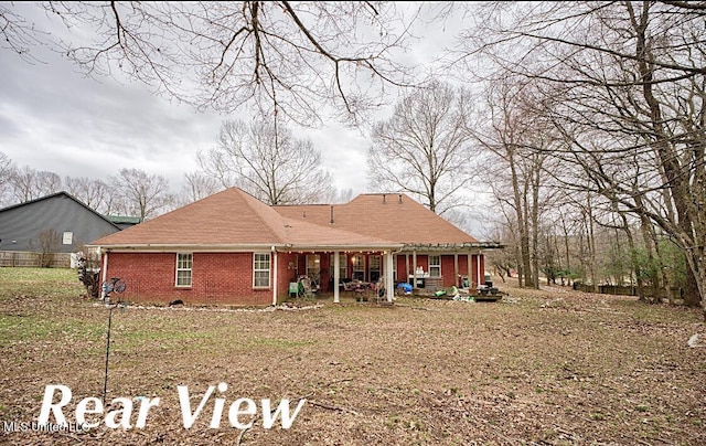 back of house featuring brick siding and fence
