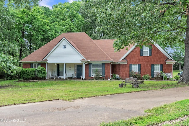 view of front of house with brick siding, a porch, and a front lawn