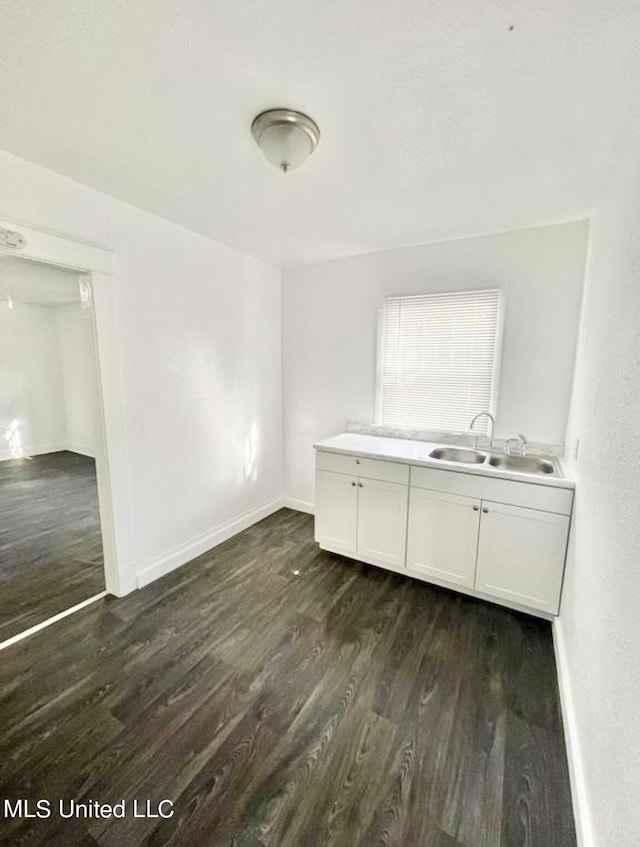 128 Carolyn Ave, Jackson, MS 39209 - unfurnished dining area featuring dark wood-type flooring, a sink, and baseboards